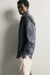 Camisa de corte regular fit confeccionada en tejido de algodón, con cuello solapa, manga larga con puños abotonados, bolsillo plastrón en el pecho y cierre frontal de botones.