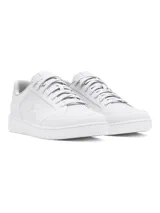 Championes Under Armour modelo Official, de diseño minimalista en color blanco. Presentan una parte superior de cuero sintético con el logo de la marca en el lateral, cierre de cordones y suela de goma estable.