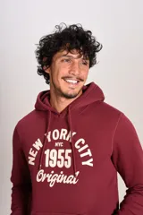 Hoodie bordó con capucha y cordones ajustables, presenta un estampado frontal con texto en color crema y bolsillo tipo canguro.