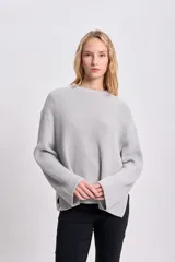 Sweater gris de punto inglés con cuello redondo y mangas largas.