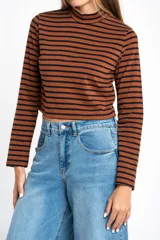 Polera de manga larga, corte ajustado al cuerpo, con cuello alto. Presenta un estampado de rayas horizontales en tonos marrón camel y azul marino.