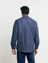 Camisa de manga larga con estampado de lunares pequeños, cuello abotonado y bolsillo en el pecho.