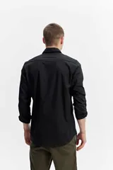 Camisa de manga larga blanca con calce semi slim, cuello camisero, cierre frontal con botones y logo bordado al tono en el pecho.