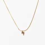Collar dorado con cadena fina y dije de rayo.