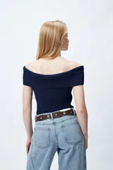 Top tejido de punto acanalado color blanco, con escote bardot que deja los hombros al descubierto.