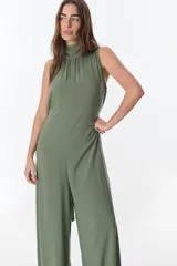 Mono color verde oliva, de corte holgado, con cuello alto y sin mangas.