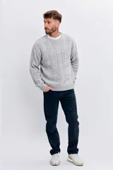 Sweater de punto con diseño de trenzas verticales, cuello redondo y puños acanalados.