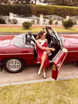 Vestido de fiesta fucsia con escote y espalda de cuero, tajos laterales con hilo metálico y terminación con flecos.