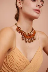 Collar babero con cadena dorada y cuentas de cristal color ámbar y perlas.