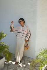 Buzo con capucha de tejido de punto abierto, color blanco roto, de corte oversize y manga larga con detalle de flecos en los puños.