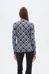 Remera de manga larga con cuello alto, confeccionada en tejido de viscosa y elastano con estampado a cuadros en tonos azul, gris y negro.