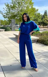 Blusa azul de manga corta con cuello redondo y detalles en turquesa en el cuello y las mangas.