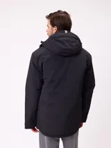 Campera técnica de invierno marca Rusty, color negro, con capucha ajustable, cierre frontal con solapa y bolsillos laterales. Presenta logo de la marca estampado en blanco en la manga y en el pecho.
