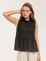 Blusa negra sin mangas con cuello alto y volado en la cadera.