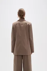 Blazer de corte holgado con diseño de rayas verticales, cuello solapa y cierre frontal con un botón. Cuenta con bolsillos laterales con solapa.