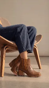 Bota tipo chelsea de cuero negro con paneles elásticos laterales y taco cuadrado de madera de 6 cm.