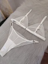 Conjunto de lencería compuesto por un corpiño triangular y una bombacha tipo colaless, confeccionados en encaje con diseño de ondas y detalles en satén.