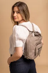 Cartera mochila color tostado, de cuero sintético, con compartimento principal amplio y bolsillos frontales con cierre. Tiene correas ajustables y asa superior para llevar al hombro o como mochila.