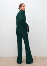 Pantalón flare verde oscuro de tiro alto, confeccionado en mezcla de lana con cintura elástica y forro interior.