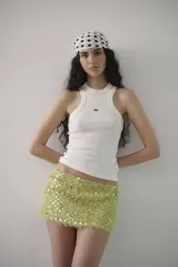 Minifalda de tiro bajo confeccionada en tejido texturizado color verde lima, con apliques de lentejuelas circulares brillantes.