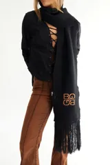 Bufanda de algodón color marrón con flecos en los extremos y logo bordado en amarillo.