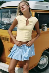 Falda mini de tiro medio con estampado de rayas celestes y blancas. Cuenta con cintura elástica ajustable con cordones, detalles de entredós en contraste y bajo con volantes.