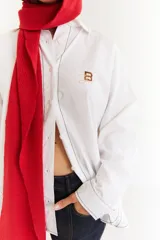 Camisa de corte oversize color bordó, con cuello camisero, mangas largas y bordado en hilo rojo en la espalda con la frase The Winter League. Presenta recortes con costuras a contratono y detalle de placa metálica pequeña en la parte superior trasera.