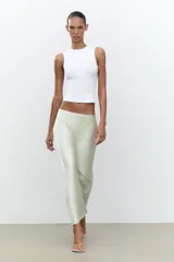 Falda midi color blanco hueso, de satén, corte al bies y cintura elástica.