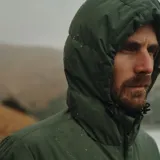 Campera puffer verde oliva con capucha, cierre frontal con cremallera, dos bolsillos de parche con solapa abotonada en el pecho y dos bolsillos laterales con cierre.