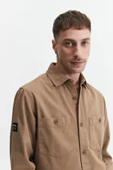 Sobrecamisa verde militar de twill de algodón, con cuello clásico, cierre frontal con botones a tono, dos bolsillos tipo parche con solapa abotonada en el pecho, mangas largas con puños abotonados y corte recto.