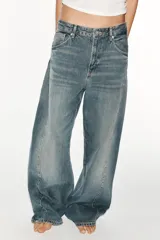 Jeans de tiro medio y corte baggy oversize con diseño de costuras marcadas en las piernas, trabillas para cinturón y cinco bolsillos tradicionales. Cierre frontal con cremallera y botón metálico.