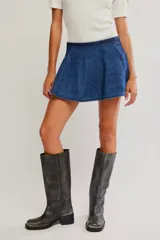 Falda pantalón de denim azul, de tiro medio y línea A, con short interno y bolsillos laterales.