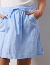 Skort blanco de algodón, marca Erika. Falda con pretina elastizada, lazo de ajuste y bolsillos laterales verticales. Incluye short interno.