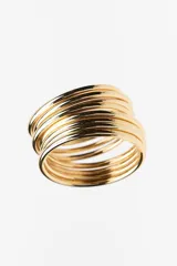 Pack de pulseras rígidas doradas, compuestas por múltiples aros delgados superpuestos, creando un efecto de brazalete ancho y texturizado.