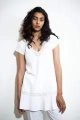 Vestido blanco con escote en V y detalles de vainillas en el escote y en el ruedo.