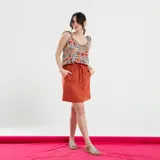 Blusa negra con estampado de flores celestes y hojas verdes, con breteles finos con volados.