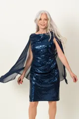 Vestido de fiesta azul con lentejuelas y capa de gasa transparente.