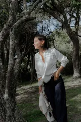 Camisa blanca de 100% algodón con cuello mao, escote en V y detalles de bordado en la parte frontal y puños.