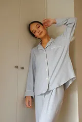 Conjunto de pijama de algodón gris con estampado geométrico blanco, compuesto por una camisa de manga larga con botones y un pantalón largo con elástico en la cintura.