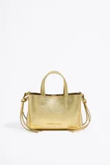 Bolso mini dorado de cuero con doble asa corta y correa fina ajustable.