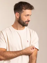 Remera básica de manga corta y cuello redondo, color blanco, con pequeño logo bordado en el pecho.