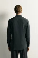 Camisa regular fit de manga larga con diseño de rayas verticales celestes y blancas, cuello italiano y cierre frontal con botones.