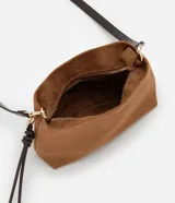 Bolso transversal Satinato de tamaño mediano, confeccionado en material sintético símil gamuza color marrón, con correa ajustable oscura, herrajes dorados y tiras decorativas colgantes con nudo.