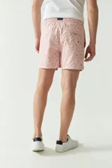 Short de baño color mostaza con estampado floral en azul marino. Cuenta con cintura elástica con cordón de ajuste, dos bolsillos laterales y uno trasero.