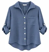 Camisa de lino color azul jean, con cuello camisero, cierre frontal con botones y un bolsillo ojal en el pecho. Presenta mangas largas con trabilla para sujetar arremangadas y dobladillo inferior curvado y más largo en la parte trasera.