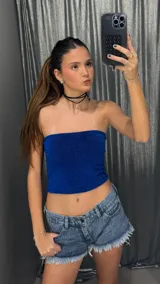 Top strapless de corte ajustado, confeccionado en tejido con acabado brillante y textura sutil. Presenta un diseño minimalista sin mangas, ideal para combinar en diversos looks.