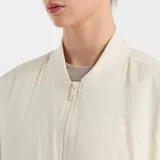 Campera bomber color crema con cierre frontal, bolsillos laterales y mangas largas.