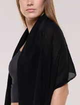 Pashmina ligera de color negro, de forma rectangular, con aplicaciones de brillos formando patrones geométricos.