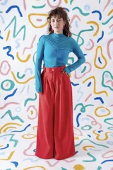 Pantalón sastrero de corte amplio y tiro alto, color rojo vibrante. Presenta pinzas en la cintura, cierre frontal con botón a la vista y diseño de pierna ancha.