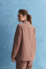 Blazer de corte sastrero con silueta relajada, solapas tradicionales, cierre frontal de un botón y bolsillos de vivo.